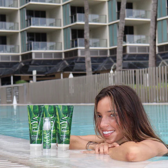 FUYA Haircare poolside collection – woman relaxing by the pool with FUYA Repair & Shine products in foreground