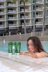 FUYA Haircare poolside collection – woman relaxing by the pool with FUYA Repair & Shine products in foreground